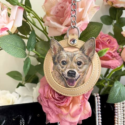 A chihuahua carved into a cream leather medallion, held among roses